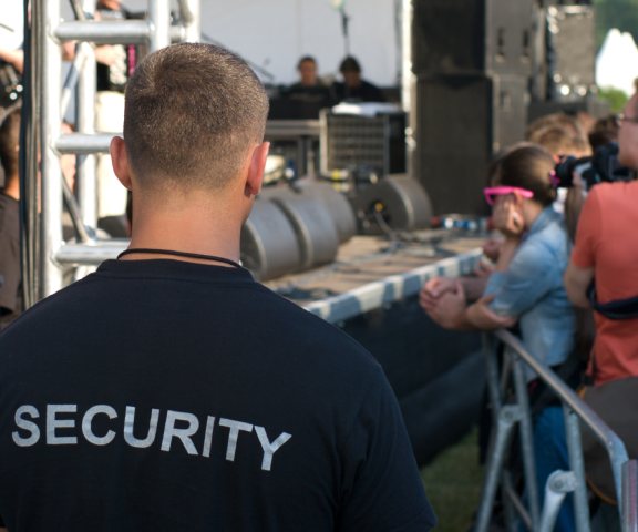 Veranstaltungsschutz: Sicherheitsmitarbeiter vor einer Bühne